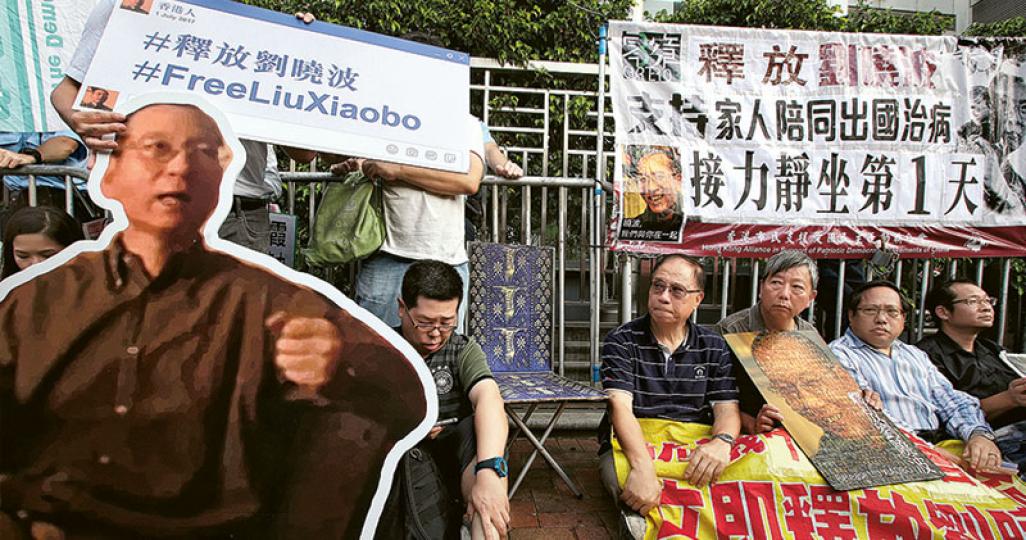 支聯會昨傍晚開始在中聯辦門外接力靜坐,促中央政府容許劉曉波由親人陪同出國治療,首輪靜坐約有30多人。支聯會秘書李卓人(右三)說,病人不僅需要藥物,亦需親友的支持及關懷,惟劉曉波至今仍無法與外界自由接觸。支聯會主席何俊仁(右二)說,若能以人道理由允許劉曉波出國治療,將展現中央政府胸襟廣闊。支聯會另呼籲公眾參與全球聯署《緊急呼籲:還劉曉波徹底自由》。(曾憲宗攝) 支聯會昨傍晚開始在中聯辦門外接力靜坐,促中央政府容許劉曉波由親人陪同出國治療,首輪靜坐約有30多人。支聯會秘書李卓人(右三)說,病人不僅需要藥物,亦需親友的支持及關懷,惟劉曉波至今仍無法與外界自由接觸。支聯會主席何俊仁(右二)說,若能以人道理由允許劉曉波出國治療,將展現中央政府胸襟廣闊。支聯會另呼籲公眾參與全球聯署《緊急呼籲:還劉曉波徹底自由》。(曾憲宗攝)