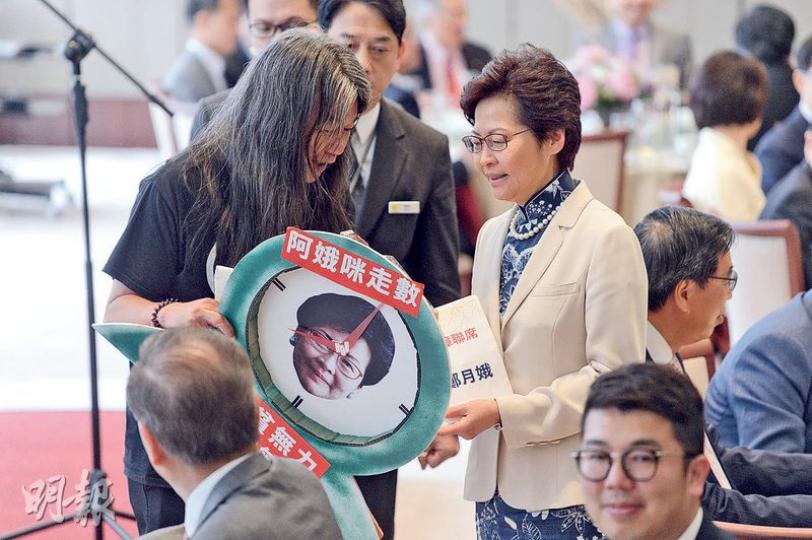 社民連梁國雄(左)噚日喺立法會午宴向特首林鄭月娥(右)請願,氣氛平和,林太仲接過印有佢頭像嘅鐘形請願物品,兩人傾咗一陣偈後,長毛就由保安陪同下離場。(鍾林枝攝) 社民連梁國雄(左)噚日喺立法會午宴向特首林鄭月娥(右)請願,氣氛平和,林太仲接過印有佢頭像嘅鐘形請願物品,兩人傾咗一陣偈後,長毛就由保安陪同下離場。(鍾林枝攝)