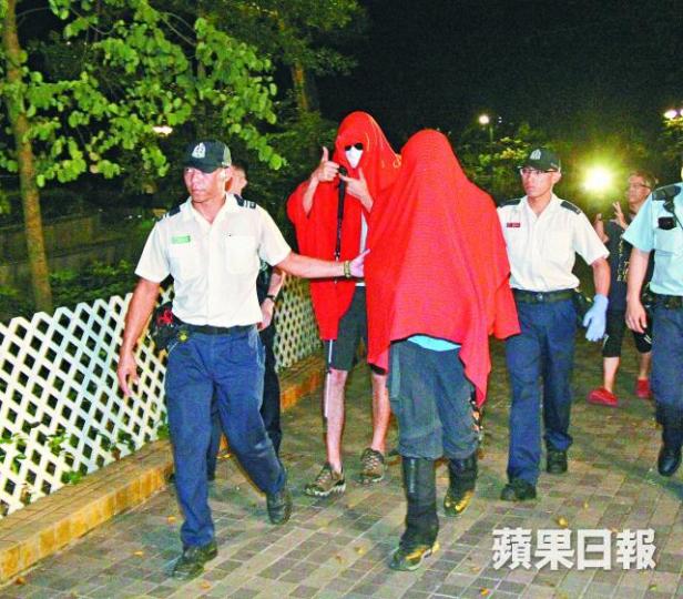 ■兩名獲救洋漢由消防員帶落山,其中一人豎起拇指。鄭文輝攝 ■兩名獲救洋漢由消防員帶落山,其中一人豎起拇指。鄭文輝攝