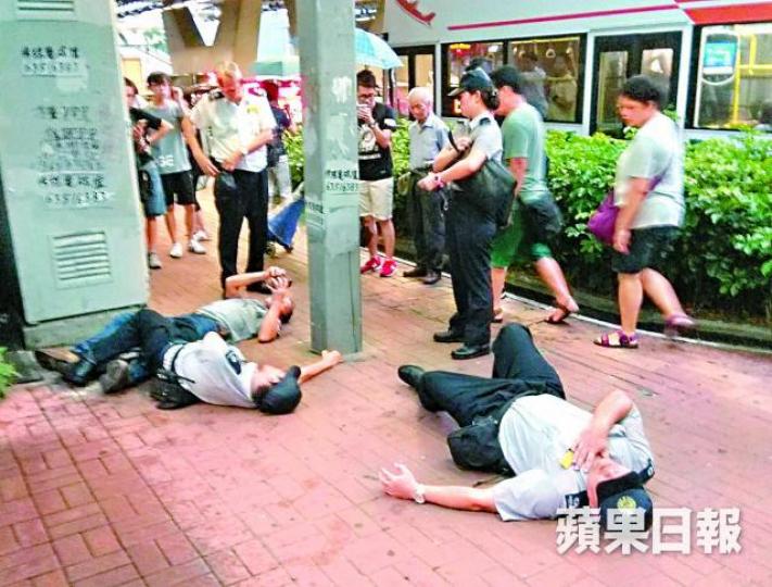 ■兩名食環署職員及一名被票控男子倒地上。文兆麟攝
■兩名食環署職員及一名被票控男子倒地上。文兆麟攝
