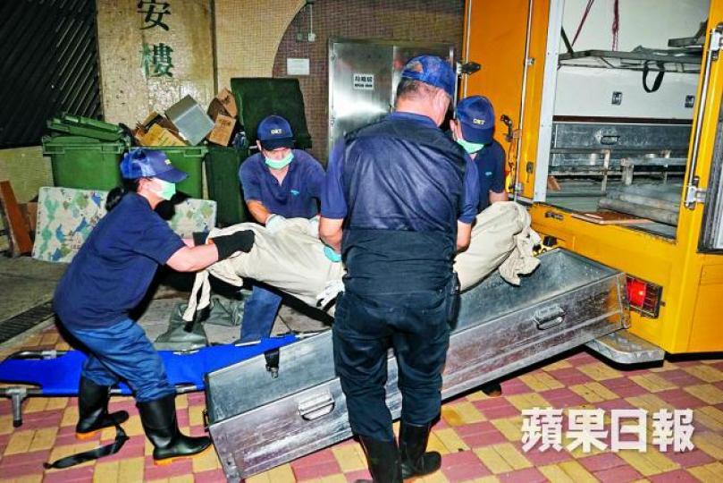 ■仵工將女死者的遺體運走。
