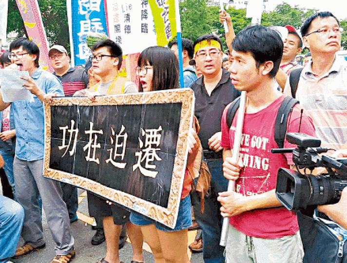■示威人士在行政院門前舉牌匾抗議。
