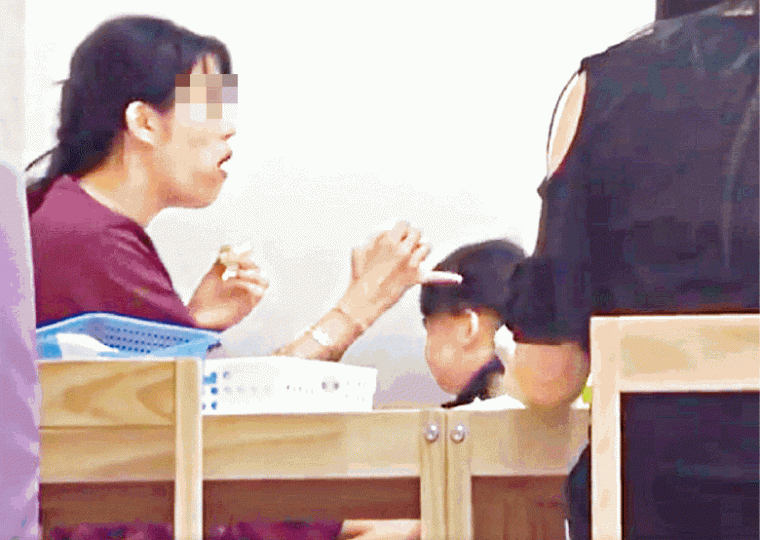 ■女導師以尾指篤女童頭部。互聯網■片中女童的上衣被扯起，露出腰部。