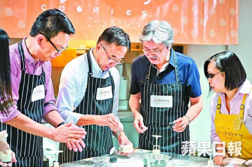 ■曾俊華（右二）與田北俊（左二）昨到視障人士社企學習製作月餅。易仰民攝
