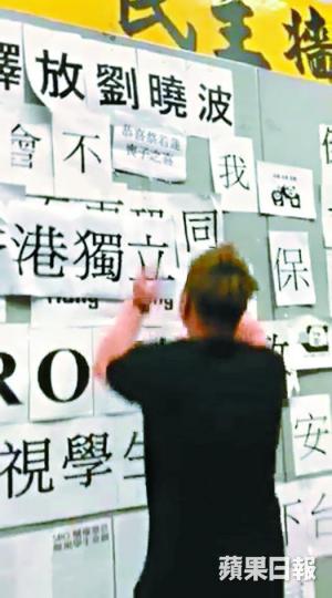 ■一名身穿黑衣的男子，昨凌晨在城大民主牆貼上侮辱蔡若蓮字句。讀者提供圖片
