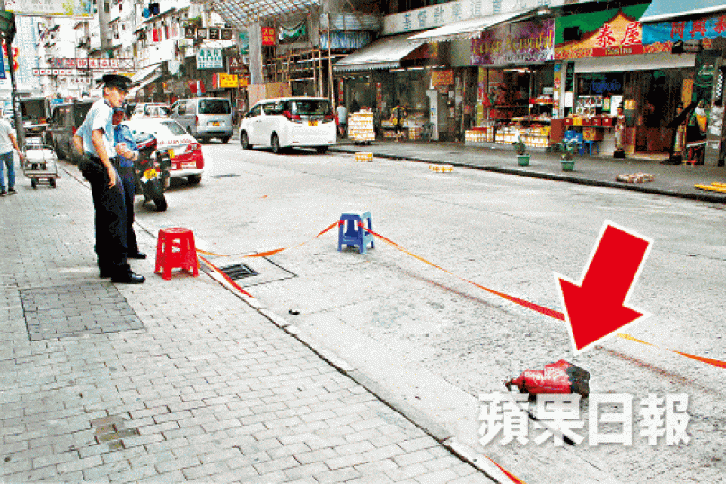 ■滅火筒（箭嘴示）墮地爆開，警員封鎖現場調查。文兆麟攝