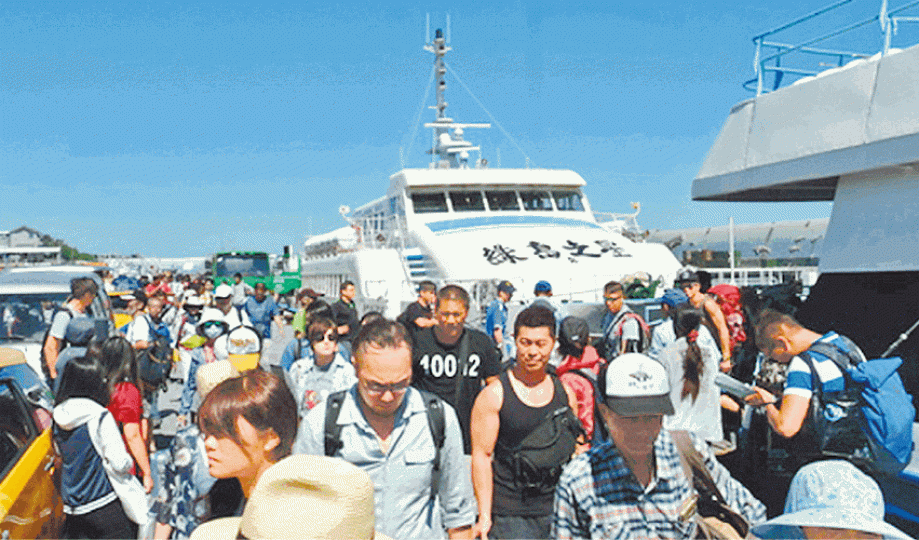 ■大批遊客在綠島排隊坐船返回本島。台灣《蘋果日報》