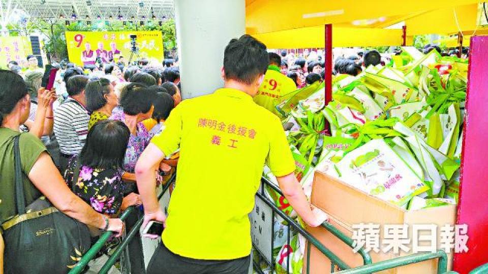 ■澳門民建聯團隊向市民派發禮物包，當中有雨衣及印有候選人姓名的杯。
