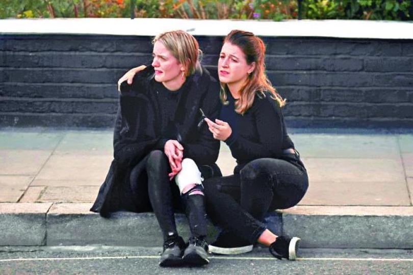 ■這名女子在爆炸中受輕傷，好友在旁安慰。路透社