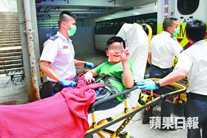 ■11歲弟弟右手受傷被送上救護車時，展示V字手勢。文兆麟攝