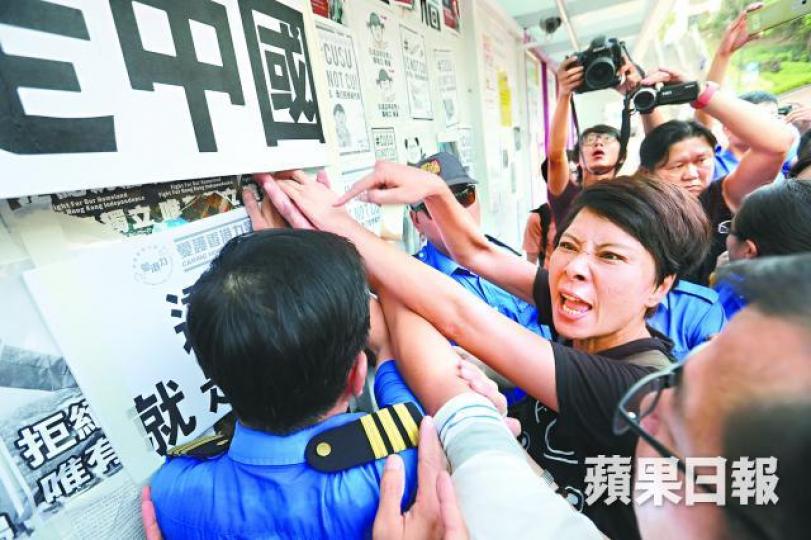 ■十數名男女手持「這裡就是中國」紙牌，在民主牆前靜坐。
