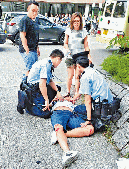 ■16歲疑犯被途人制服，糾纏間雙膝擦傷流血。讀者提供圖片■疑犯的母親（右）事後到場陪伴在側。周鴻熙攝■警方到場搜集證物。
