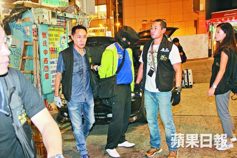 ■其中一名劫匪被擒後遭蒙頭帶署扣查。溫文學攝■重案組探員事後在錶行搜證及翻查閉路電視。 ■其中一名劫匪被擒後遭蒙頭帶署扣查。溫文學攝■重案組探員事後在錶行搜證及翻查閉路電視。