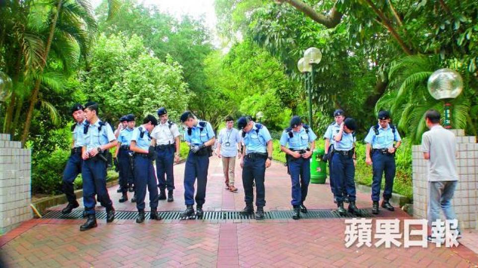 ■大批警員在九龍公園地氈式搜索，尋找公園內有否其他贓物。翁鈺輝攝■警員在草叢撿獲兩把大鐵鎚。