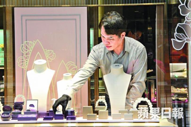 ■發生劫案的周生生珠寶行，職員昨如常在曾被扑爆玻璃的櫥窗擺放首飾。■櫥窗內昨展示最貴的首飾價值逾49萬元。
