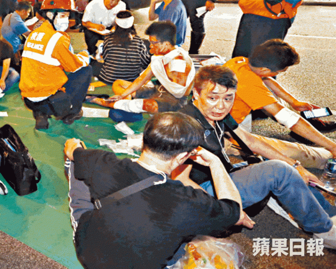 ■大難不死的梁先生（右一）及林先生（右二）事後坐在地上等候送院。