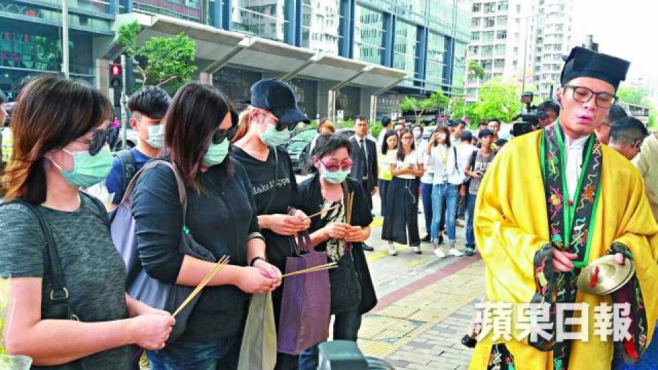 ■死者李健華的家屬按道士指示持香拜祭。