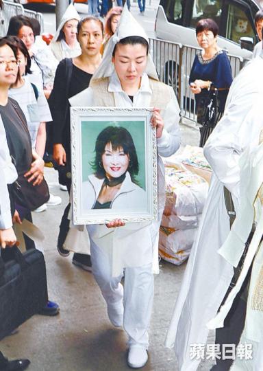 ■廖麗麗女兒Sindy捧着亡母遺照，神情悲傷。■丁羽送亡友最後一程。
