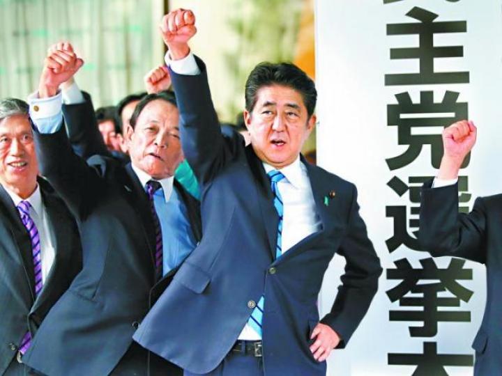 ■安倍（右）在自民黨總部與黨友揮拳，矢言勝出大選。　路透社