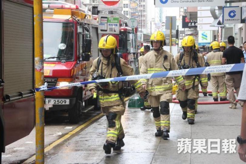 ■油麻地寶聲大廈一個單位起火，消防到場開喉灌救。梁澤岡攝
