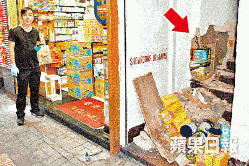 ■藥房與梯間牆壁被賊人鑿穿大洞（箭嘴示）。謝志輝攝
