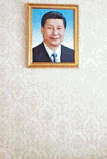 ■新疆不少少數民族家庭被迫掛上習像。■新疆兒童也要持五星旗參加國慶活動。