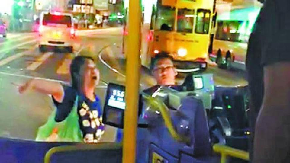 ■涉事情侶站在車頭阻止巴士行駛，隔着擋風玻璃指罵車長。■有途人上前勸阻，雙方扭作一團，攔車漢騎在途人身上。