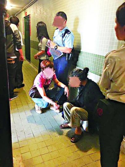 ■持刀婦人（黑衣者）被警員制服，事後送院檢驗。讀者提供圖片

