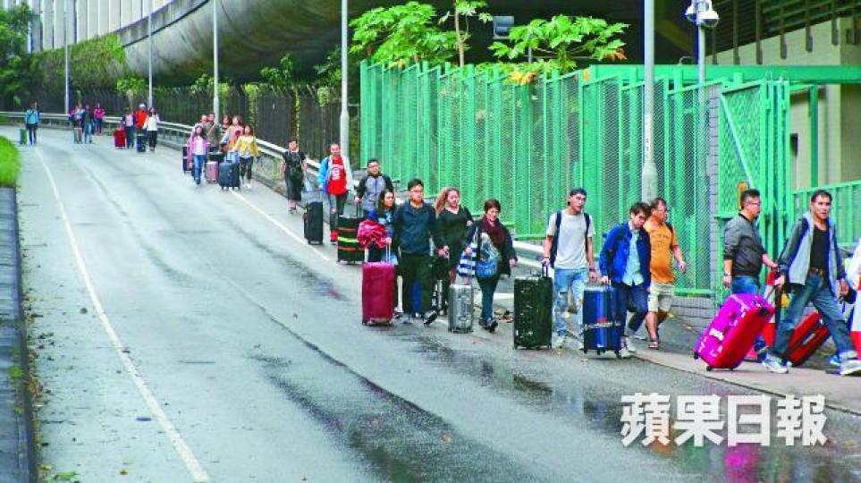 ■因嚴重塞車,大批旅客於青衣北岸公路落車,拖篋徒步往青衣站趕乘機鐵。文兆麟攝 ■因嚴重塞車,大批旅客於青衣北岸公路落車,拖篋徒步往青衣站趕乘機鐵。文兆麟攝