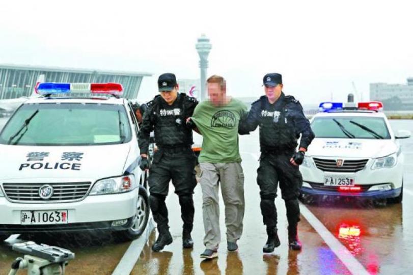 ■中國警方昨在上海浦東國際機場將美國通緝犯移交美方。 ■中國警方昨在上海浦東國際機場將美國通緝犯移交美方。
