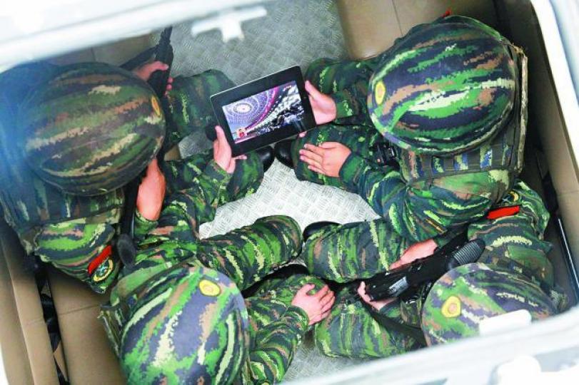 ■兩名大陸解放軍收看習近平在十九大作報告。 路透社 ■兩名大陸解放軍收看習近平在十九大作報告。 路透社