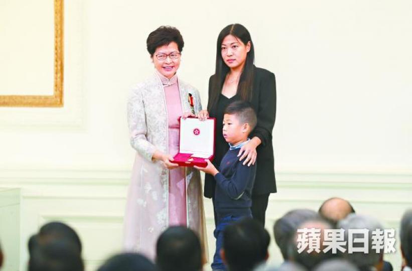 ■林鄭日前向殉職消防總隊目邱少明遺孀追授勳章時面帶笑容,被轟涼薄。 ■林鄭日前向殉職消防總隊目邱少明遺孀追授勳章時面帶笑容,被轟涼薄。