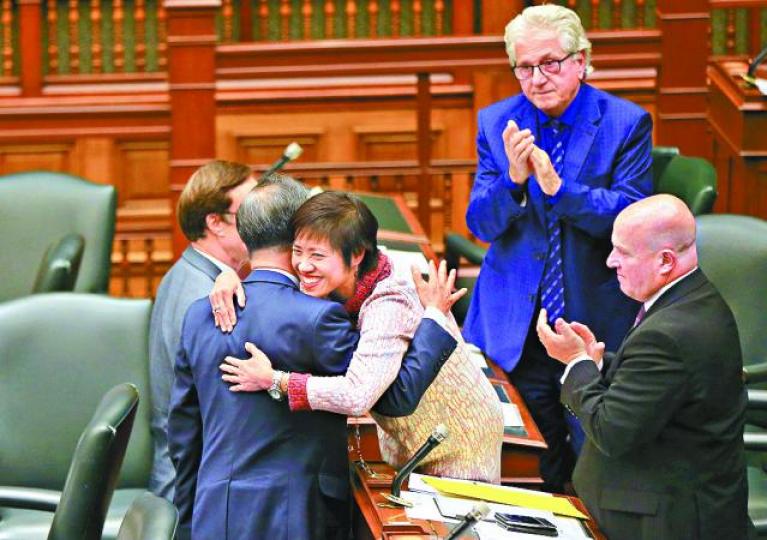 ■黃素梅(中)慶祝動議獲通過。 新華社 ■黃素梅(中)慶祝動議獲通過。 新華社
