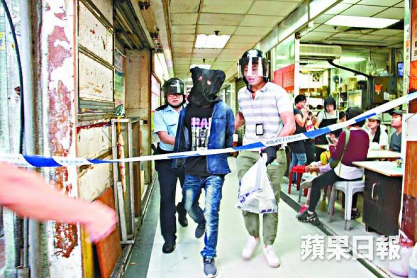 ■持刀漢被黑布蒙頭押走。
■持刀漢被黑布蒙頭押走。