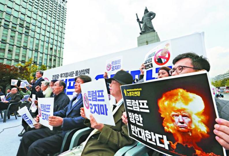 ■南韓反特朗普示威者展示醜化他的照片。美聯社 ■南韓反特朗普示威者展示醜化他的照片。美聯社
