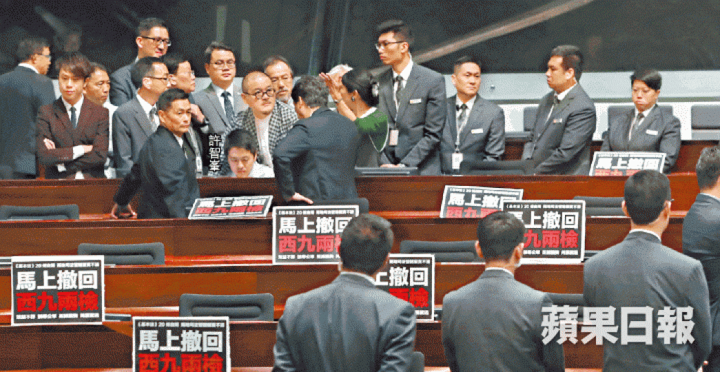 ■民主黨許智峯昨被逐離場,泛民議員即上前保護,多名立會保安在旁戒備。何柏佳攝 ■民主黨許智峯昨被逐離場,泛民議員即上前保護,多名立會保安在旁戒備。何柏佳攝
