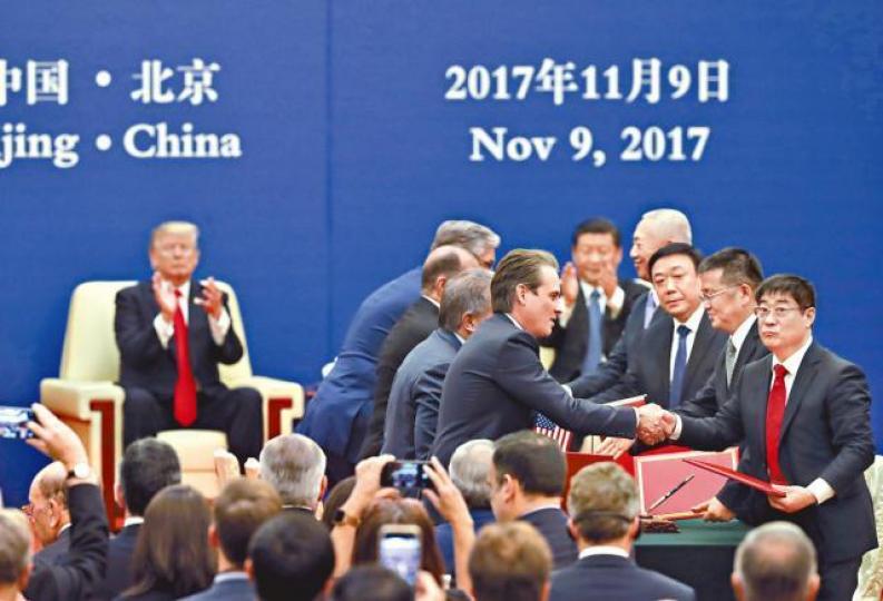 ■中美商界代表簽署交換諒解備忘錄,特朗普(後左)及習近平(後右)鼓掌致意。美聯社 ■中美商界代表簽署交換諒解備忘錄,特朗普(後左)及習近平(後右)鼓掌致意。美聯社