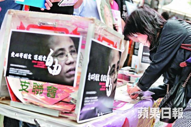 ■有市民在支聯會街站為聖誕卡簽名。
■有市民在支聯會街站為聖誕卡簽名。