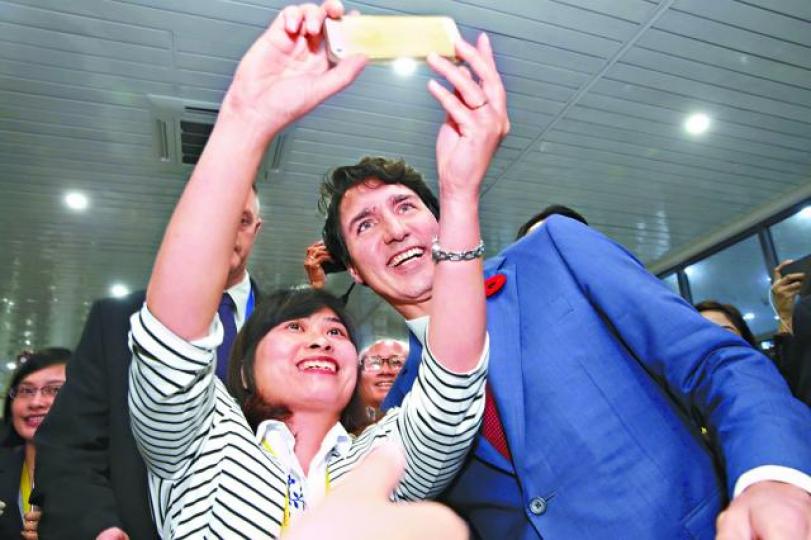 ■加拿大總理杜魯多(右)與民眾自拍。 美聯社
■加拿大總理杜魯多(右)與民眾自拍。 美聯社