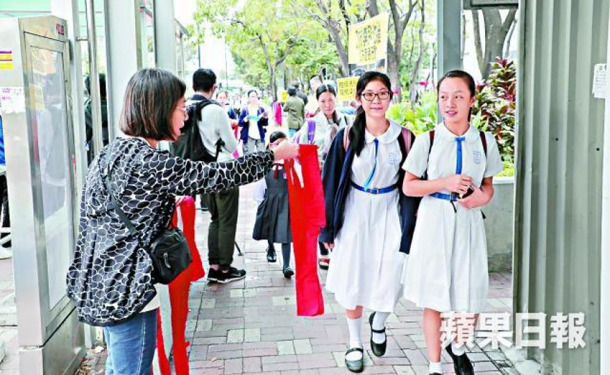 ■團體向學生派紅布,籲收看李飛演講時蒙眼。 ■團體向學生派紅布,籲收看李飛演講時蒙眼。