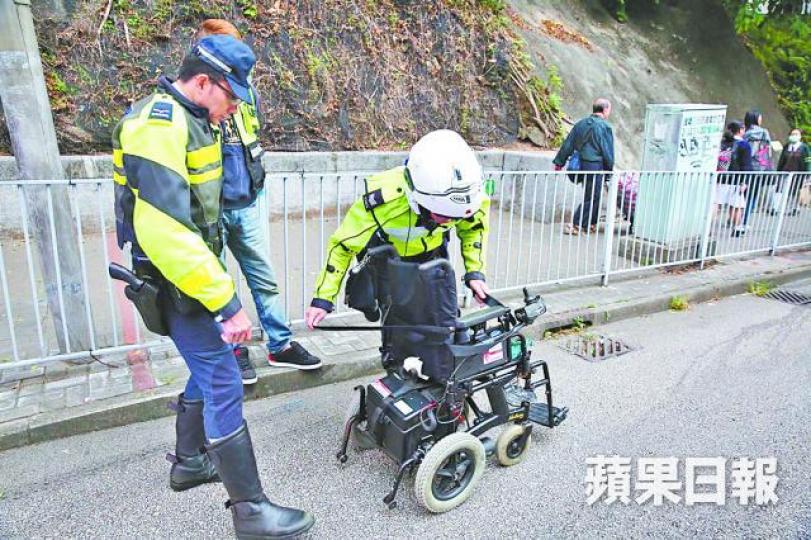 ■電動輪椅損毀翻側在地,警員在現場調查。
■電動輪椅損毀翻側在地,警員在現場調查。