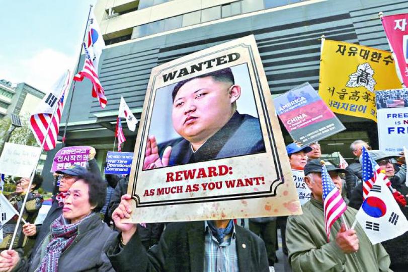 ■反北韓人士舉金正恩照片示威。美聯社 ■反北韓人士舉金正恩照片示威。美聯社