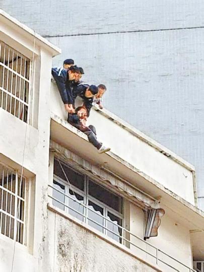 ■數名警員一度俯身伸手捉着事主的衣衫免他墮下。互聯網
■數名警員一度俯身伸手捉着事主的衣衫免他墮下。互聯網