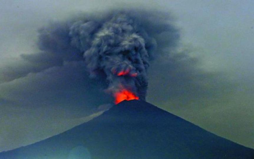 ■阿貢火山昨晚除繼續噴出大量火山灰，並見溶岩火舌的橙光。美聯社■峇里伍拉賴國際機場的登機櫃枱前逼滿滯留旅客。路透社