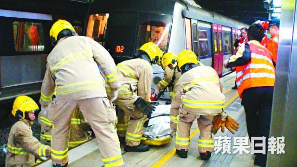 ■消防員將男生遺體移回月台。文兆麟攝■留學生母親睹子跳軌後情緒激動,送院檢驗。 ■消防員將男生遺體移回月台。文兆麟攝■留學生母親睹子跳軌後情緒激動,送院檢驗。