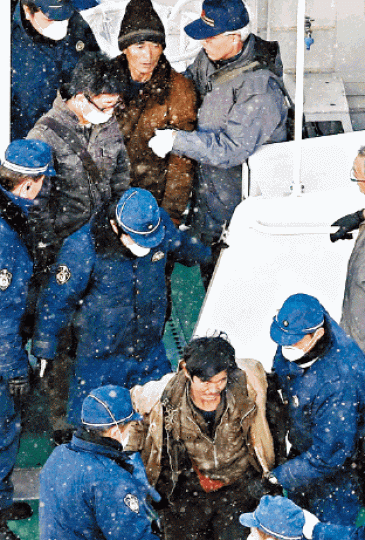 ■日本警方押解被捕北韓船員。 路透社 ■日本警方押解被捕北韓船員。 路透社