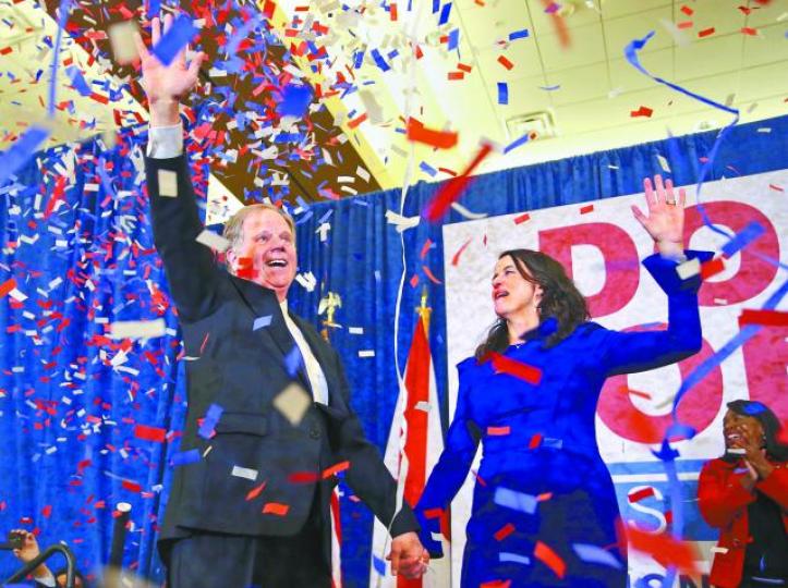 ■瓊斯慶祝勝選,拖着妻子熱情地向支持者揮手。美聯社■瓊斯的支持者歡呼,慶賀意料之外的勝利。 美聯社 ■瓊斯慶祝勝選,拖着妻子熱情地向支持者揮手。美聯社■瓊斯的支持者歡呼,慶賀意料之外的勝利。 美聯社