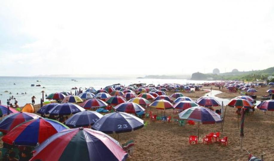 ■墾丁旅客大減,海灘插滿太陽傘卻少有遊人享用。 ■墾丁旅客大減,海灘插滿太陽傘卻少有遊人享用。