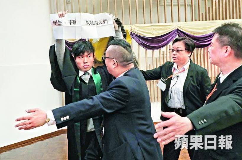 ■默坐抗議的學生被趕離場時高舉標語。
■默坐抗議的學生被趕離場時高舉標語。