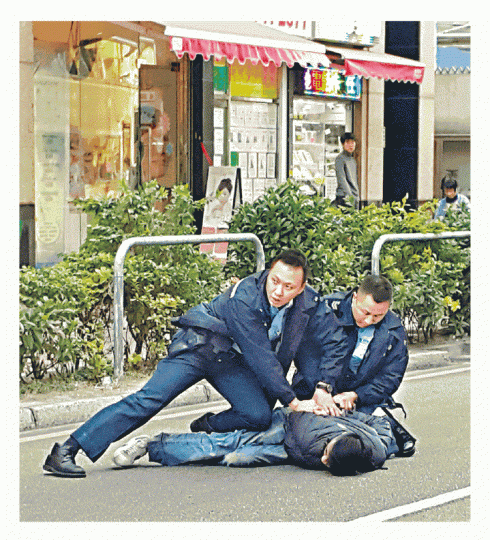 ■警員制服其中一名疑犯。讀者朱先生提供圖片■涉案寶馬車尾沒掛車牌,駛至馬頭角道被截停。 ■警員制服其中一名疑犯。讀者朱先生提供圖片■涉案寶馬車尾沒掛車牌,駛至馬頭角道被截停。